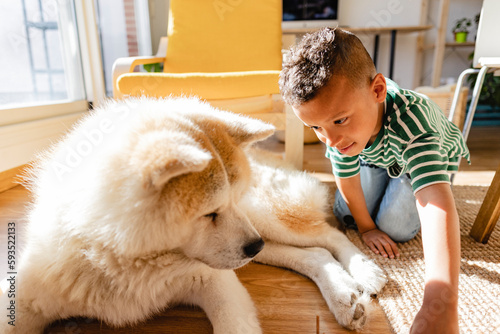 Boy playing with dog at home