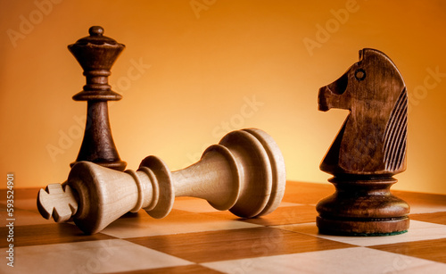 Chess pieces on a chessboard. Game of chess. Mat to the king. photo