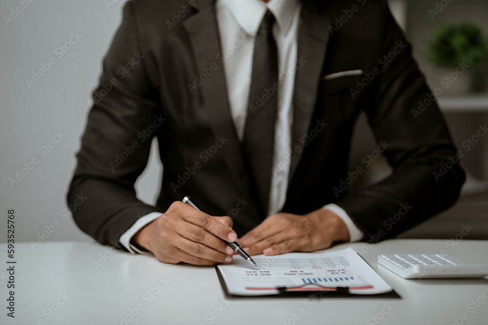 businessman working on desk office with using a calculator to calculate the numbers, finance accounting concept businessman working on desk office with using a calculator to calculate the numbers, finance accounting concept