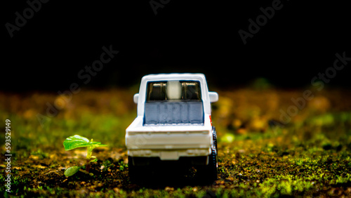 South Minahasa, Indonesia : January 2023, a toy car on a mossy floor that looks like grass photo