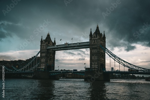 Scene of the Tower Bridge reflected on the River Thames under a cloudy sky in London  UK