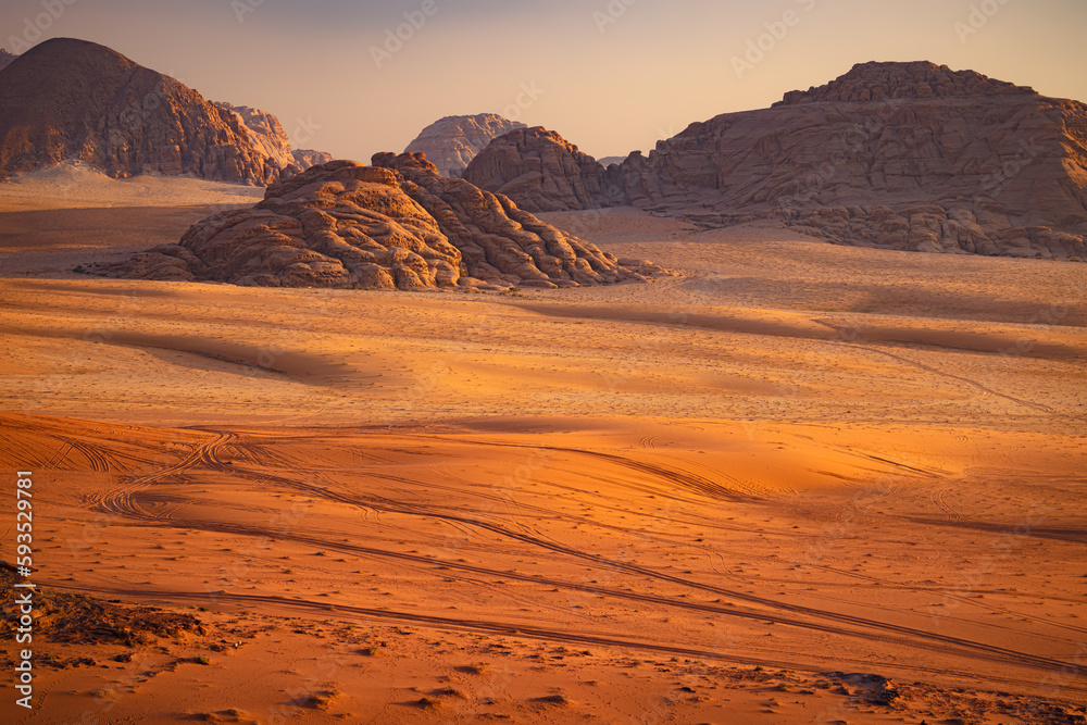 Wadi Rum w Jordanii. Ślady na gorącym pustynnym piasku na tle formacji skalnych. - obrazy, fototapety, plakaty 