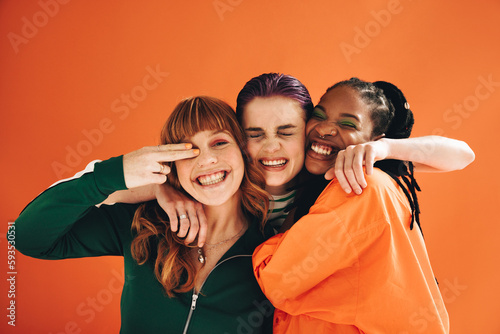Multicultural female friends smiling and embracing each other in a studio