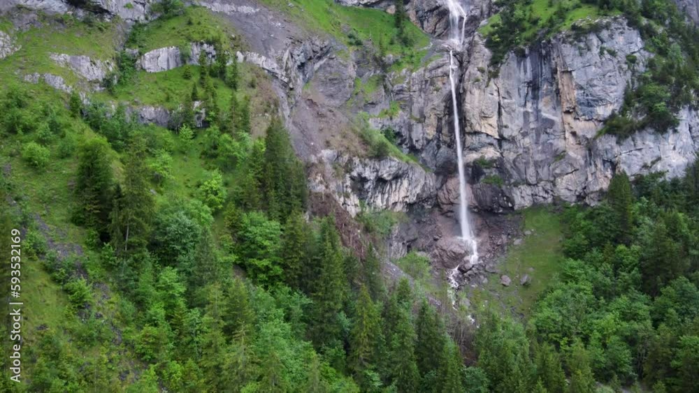Aerial Descending Drone view of Almenbachfall waterfall in Kandertal flowing among pine trees and alpine rocks, Kandersteg Berner Oberland Switzerland Aerial Descending Drone view of Almenbachfall waterfall in Kandertal flowing among pine trees and alpine rocks, Kandersteg Berner Oberland Switzerland