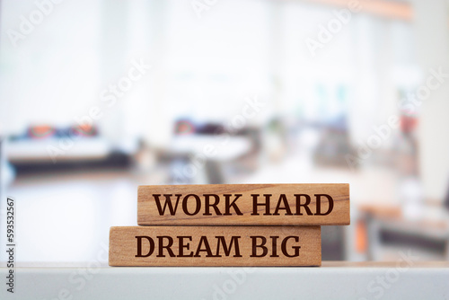 Wooden blocks with words 'WORK HARD DREAM BIG'.
