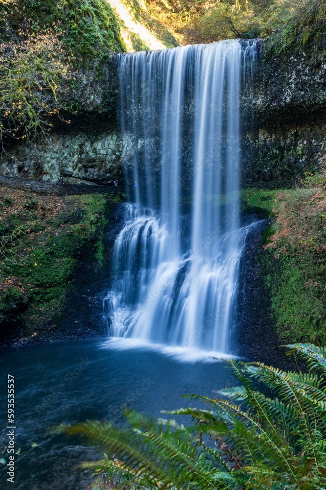 Closeup of the waterfall o the rocky mount in the colorful park.