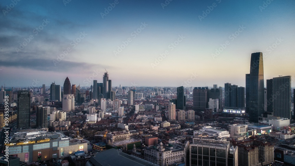 Aerial shot of a modern cityscape under the cloudy sunset