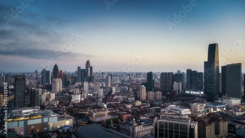 Aerial shot of a modern cityscape under the cloudy sunset © Yang6/Wirestock Creators