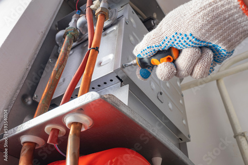 Service maintenance engineer repairs gas boiler of heating system. Home autonomous heating.
