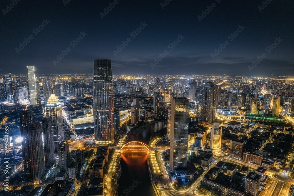 Drone modern cityscape view with a river and illuminated buildings at night Drone modern cityscape view with a river and illuminated buildings at night
