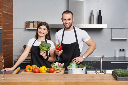 Young couple coocking salad in the kitchen photo