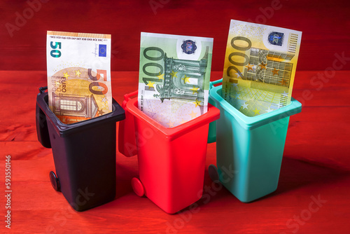 Euro Geldschein in einer Mülltonne als Symbol für Müllgebühren, Geldverschwendung