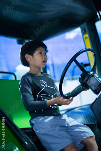 A boy learning to drive a model car in a museum