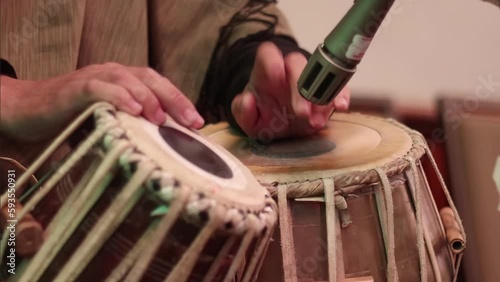 4K Medium close up of a mans hands tapping out a rhythm on a pair of tabla drums