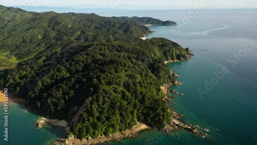 aerial of Abel Tasman national Park. anapai bay New Zealand scenic natural drone footage of peninsula covered in green lush vegetation with amazing ocean cliff photo