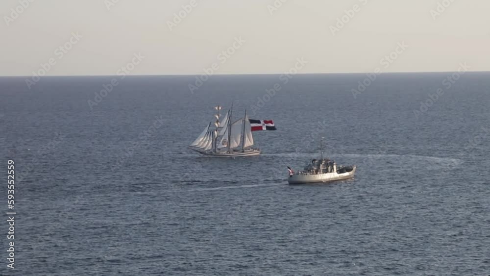 View from afar at sea, Dominican Republic Independence Day holiday, ships with flag crossing the sea. View from afar at sea, Dominican Republic Independence Day holiday, ships with flag crossing the sea.