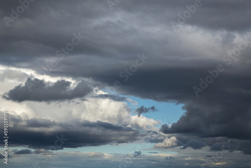 Storm cloudy dramatic sky with dark rain grey cumulus cloud and blue sky background texture, thunderstorm, heaven