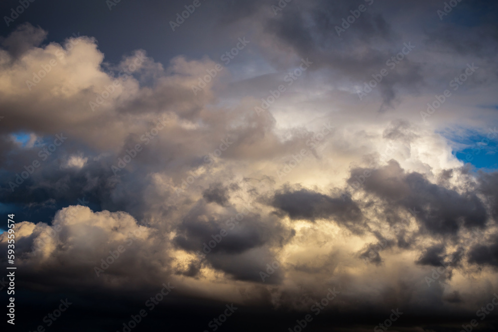 Storm cloudy dramatic sky with dark rain grey cumulus cloud in sunlight and blue sky background texture, thunderstorm, heaven