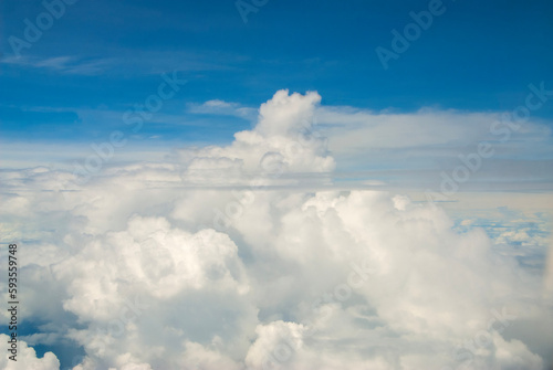 Fluffy clouds. Beautiful dramatic sunset sky above fluffy clouds in early morning from aerial drone view. Traveling by air. View from an airplane window. Aerial view of Malaysia.White clouds floating 