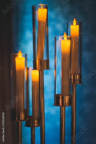 Vertical shot of long candles lighted on blur background