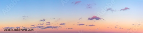 Ultra-wide panorama of the sunset sky. Light separated colored clouds. There are no birds in the sky.