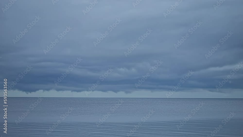 Timelapse of storm clouds moving across grey sky over ocean. Static wide shot Timelapse of storm clouds moving across grey sky over ocean. Static wide shot