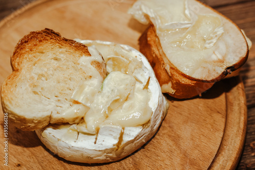 White baguette with olive oil and baked Camembert cheese on the table.