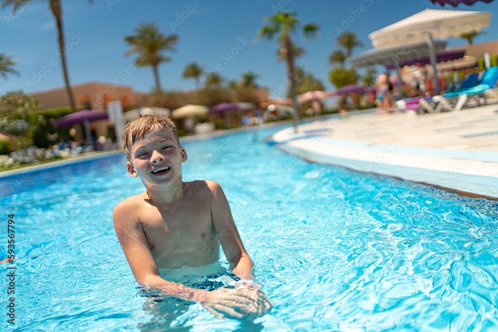 a boy is swimming in the pool. rest at the hotel