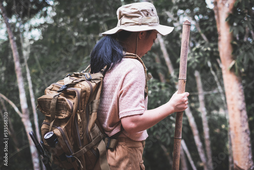 Young woman with backpack hiking in the deep jungle