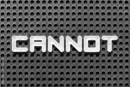 White alphabet letter in word cannot on black pegboard background