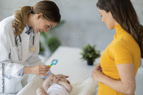 Pediatrician examining cute little baby in clinic