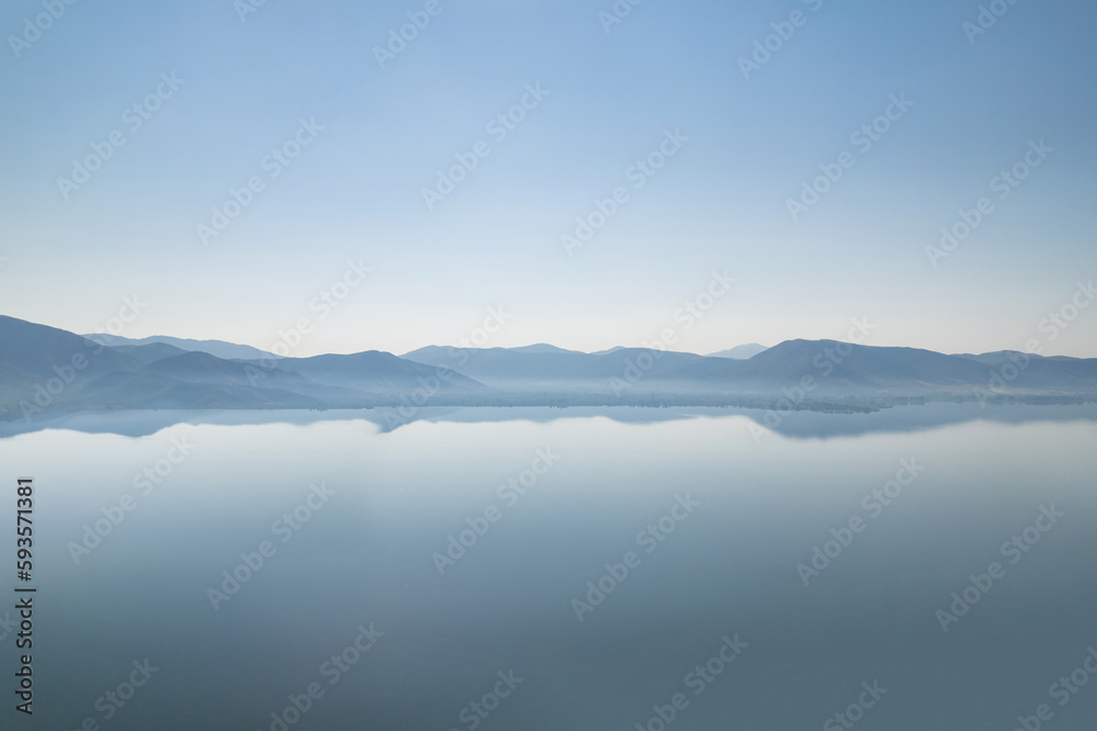 Silhouette of mountains near lake at the early morning with clear sky