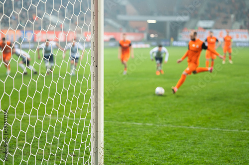 Obraz na płótnie Detail of goal's post with net and football player during penalty kick in the background. w salonie