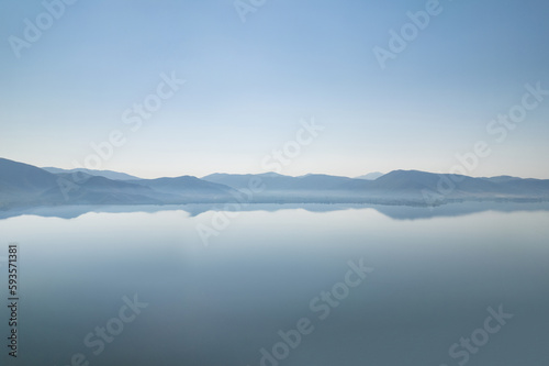 Silhouette of mountains near lake at the early morning with clear sky © flowertiare
