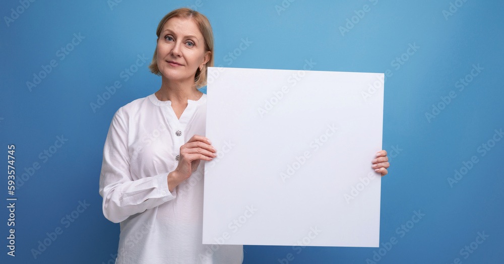 mature woman holding white sheet of paper for information with mocup mature woman holding white sheet of paper for information with mocup