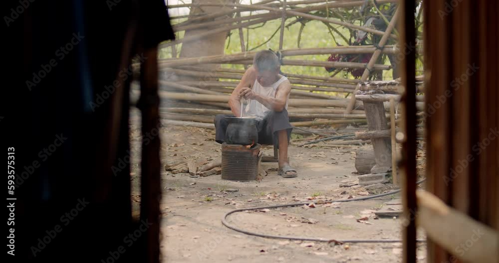 Slow motion Asian rural life in the morning which is a poor lonely elderly man, farmer and employee in the farm, cooking using a stove with firewood in front of his old house. Slow motion Asian rural life in the morning which is a poor lonely elderly man, farmer and employee in the farm, cooking using a stove with firewood in front of his old house.
