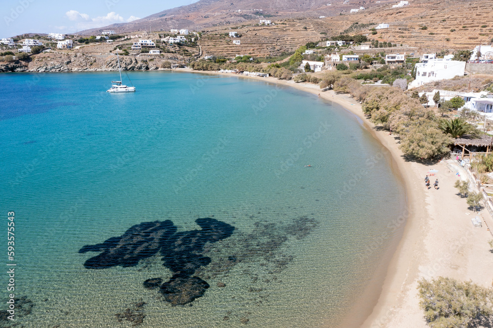 Obraz premium Tinos island, Cyclades Greece. Aerial drone view of Agios Romanos village, calm sea, sandy beach.