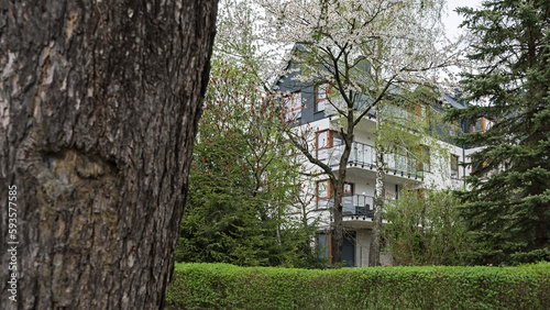 Detal na elewacje i balkony w nowoczesnym budynku wielorodzinny w europejskim mieście. Ciekawa architektura. Wśród roślinności i drzew. Kwitnąca wiosna