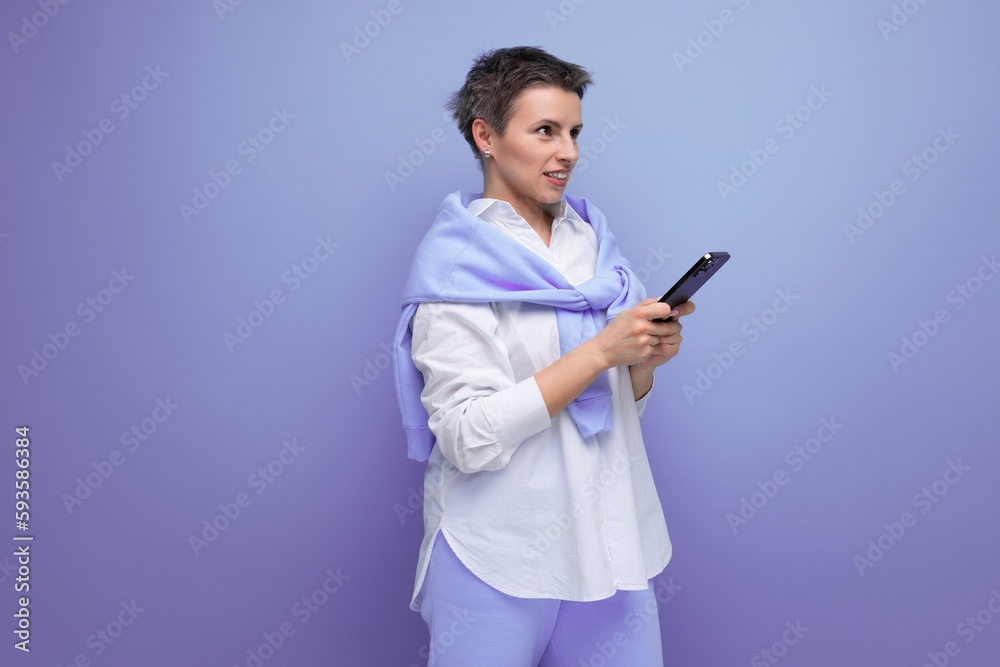 upset young dark-haired woman with sticking hair in a white shirt with a smartphone in her hands upset young dark-haired woman with sticking hair in a white shirt with a smartphone in her hands