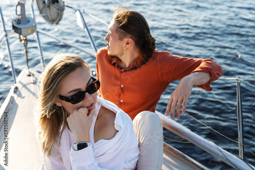 Young attractive couple relaxing on the sailboat during sailing in the sea