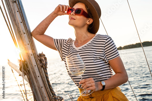 Attractive woman drinking wine and relaxing on sailboat  during sailing in sea © blackday
