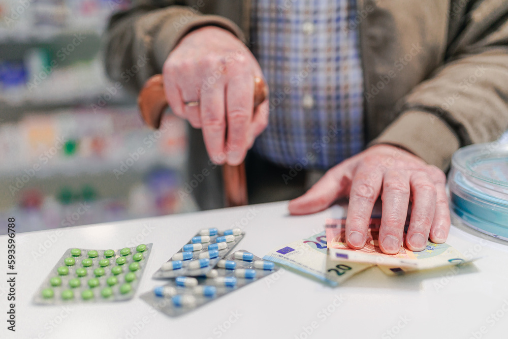 Close up of senior holding pills in a pharmacy.