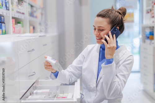 Tableau sur toile Young pharmacist checking medicine stock in pharmacy.