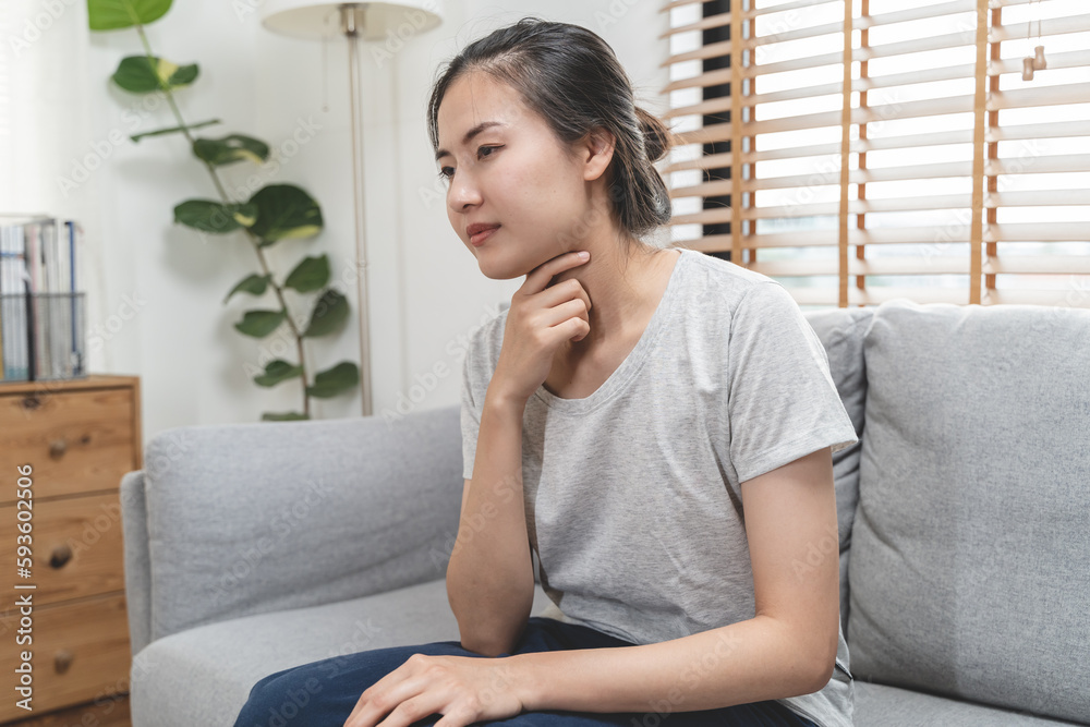 asian woman coughing and feeling sore throat at home. asian woman coughing and feeling sore throat at home.