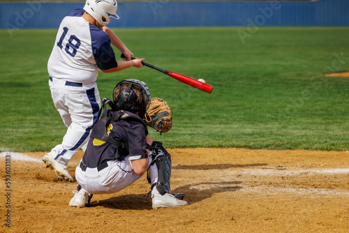 Baseball Player - Batter hitting the ball. Catcher ready at the plate