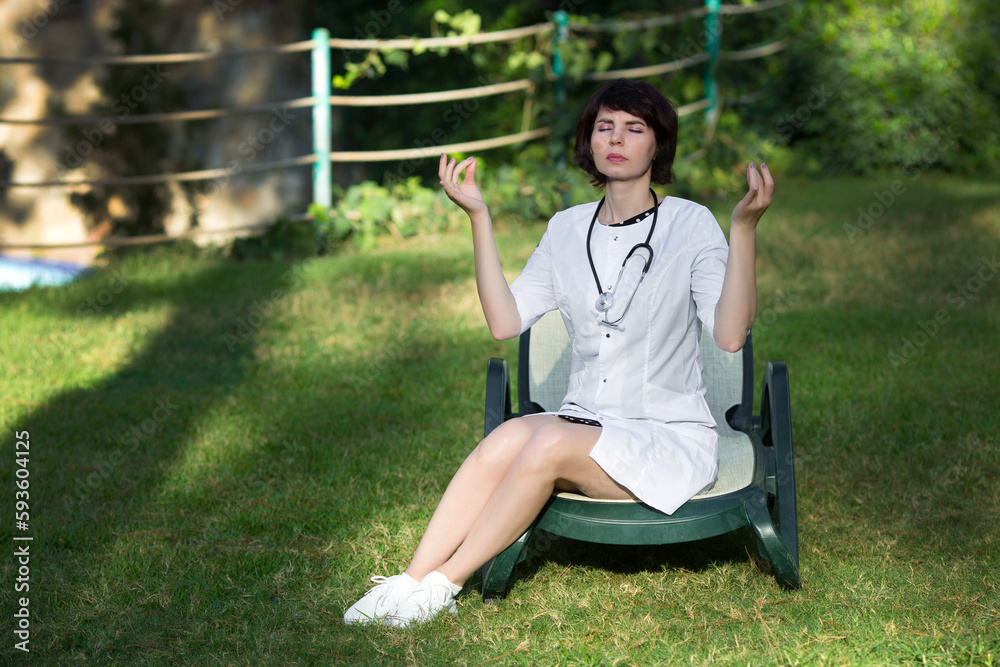 Doctor meditates resting in the park on green grass. Doctor meditates resting in the park on green grass.