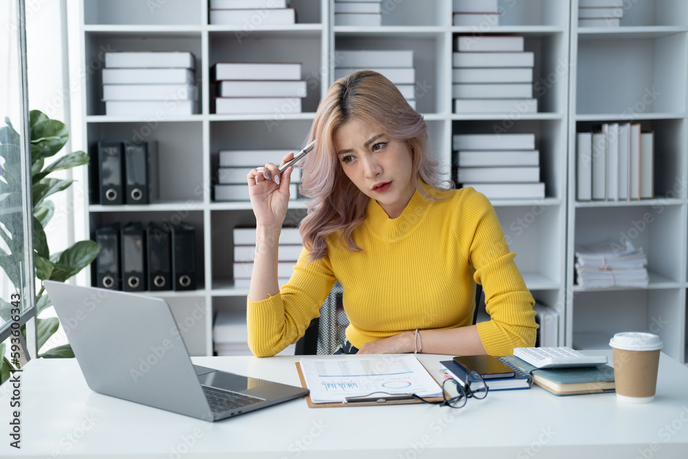 Tired Asian business woman with headache at office, feeling sick at work. Tired Asian business woman with headache at office, feeling sick at work.