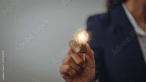 Business idea concept, Hands of business woman in suit holding light bulb with innovation and inspiration creative agency new beginning Analyzing data