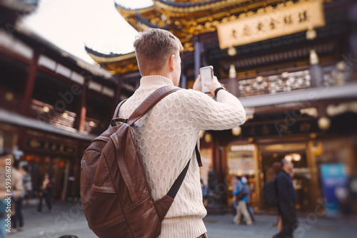 Photography male tourist taking photos of a pagoda at Yuyuan market in Shanghai