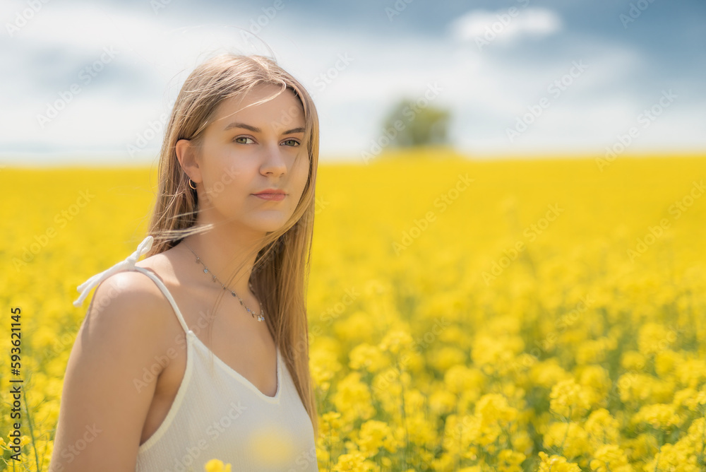 Beautiful woman with long blonde hair. He walks in the rapeseed field Beautiful woman with long blonde hair. He walks in the rapeseed field